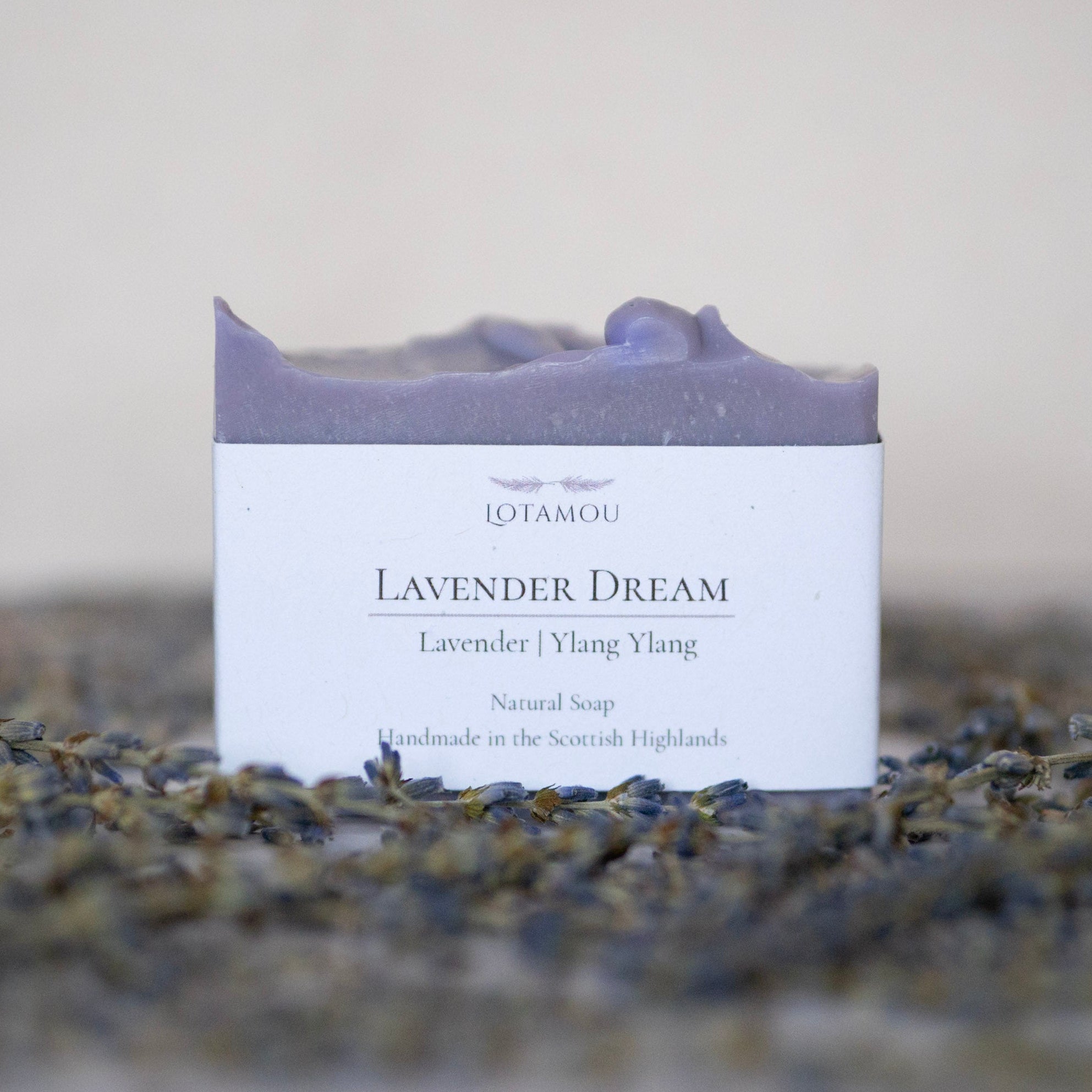 Lavender soap bar with packaging labeled 'Lavender Dream' on a bed of lavender flowers.