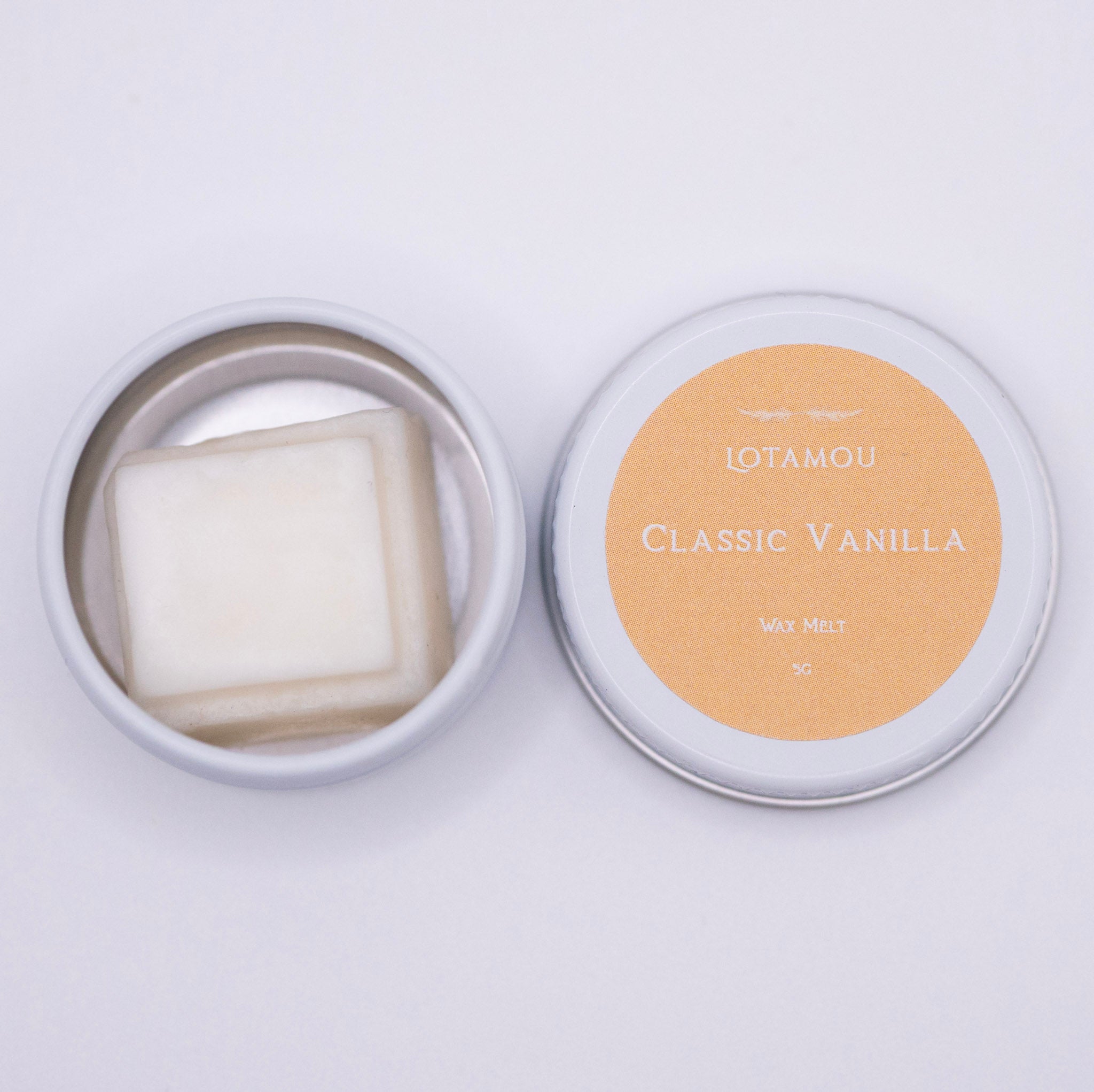 Vanilla-scented wax melt in a tin with 'LOTAMOU' branding on a light background