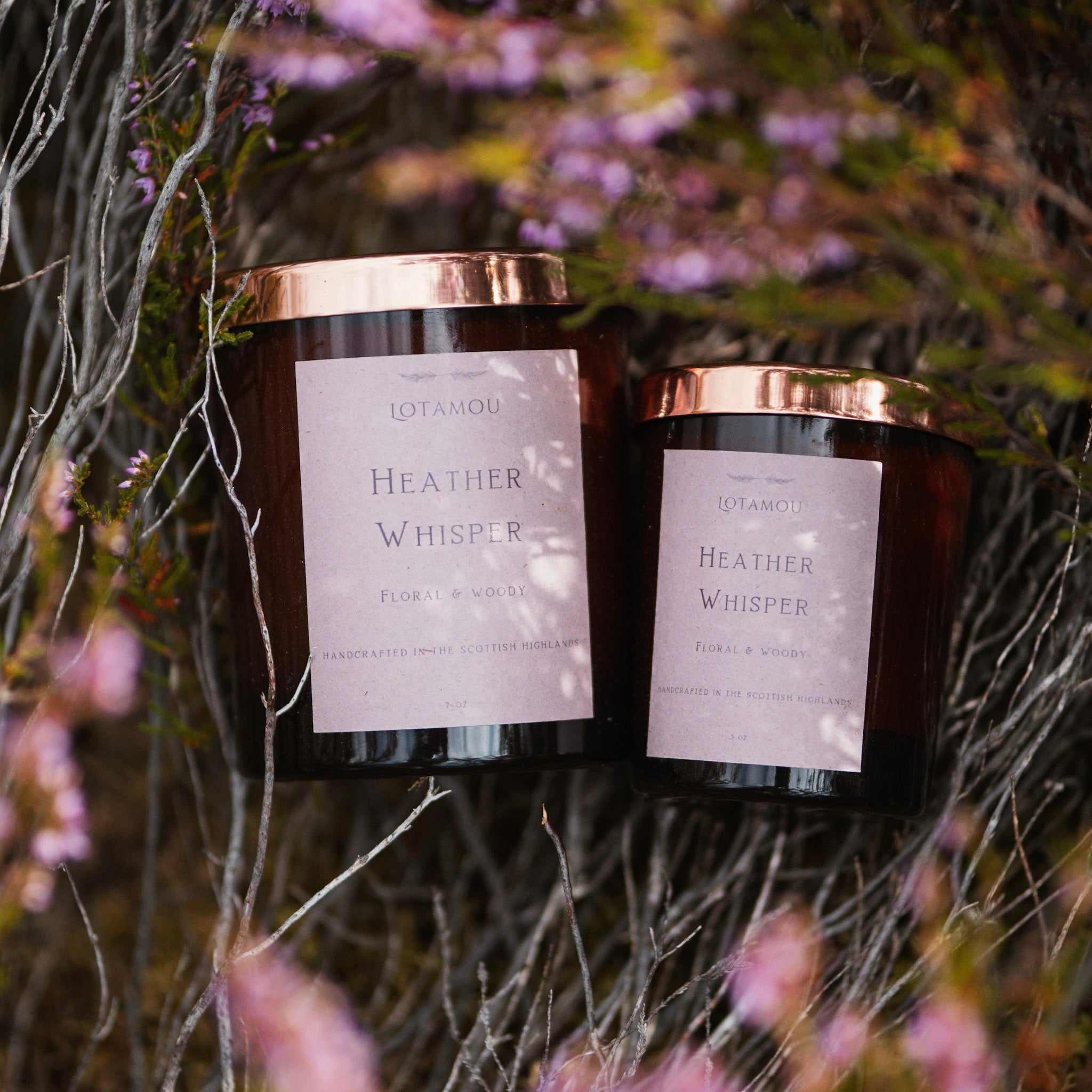 Two candles labeled 'Heather Whisper' with a natural, floral background.