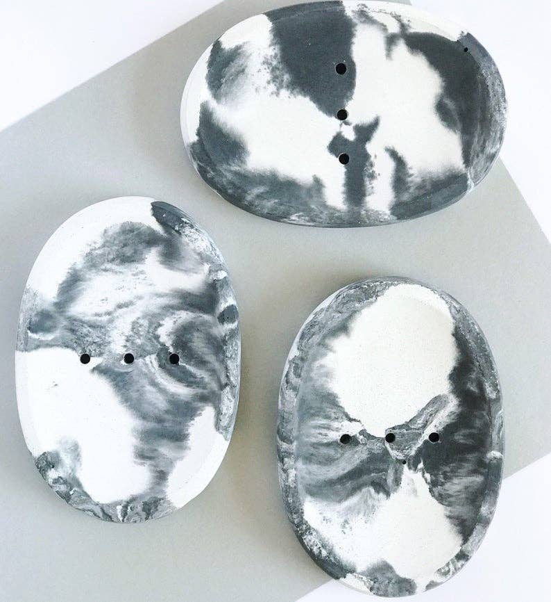 Three oval-shaped marbled black and white objects on a white background